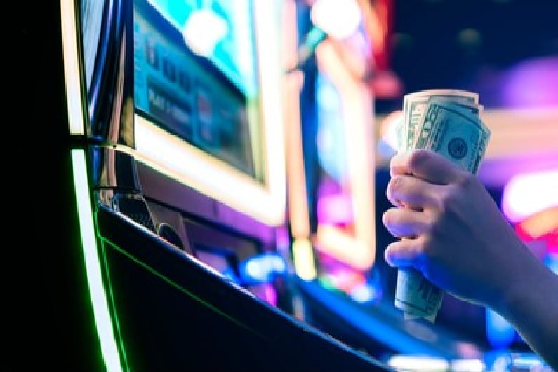 Fistful of cash at a slot machine