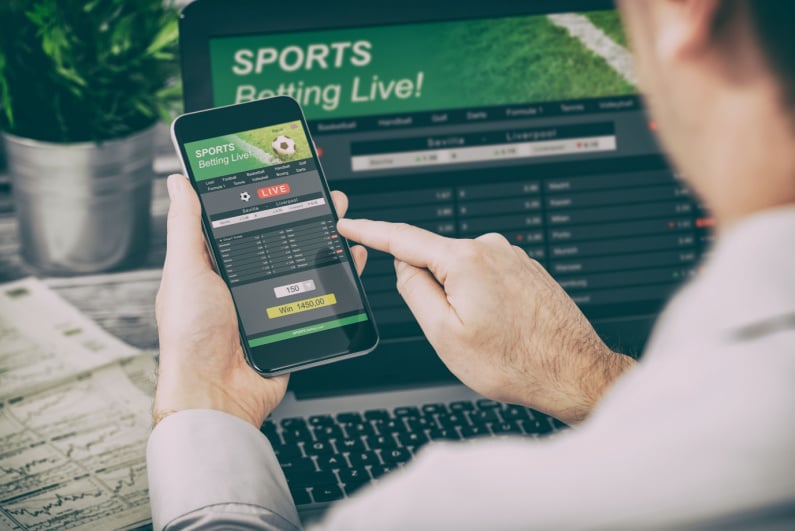 Man betting on sports on his phone