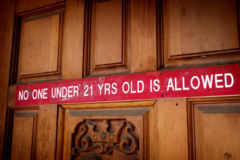 "NO ONE UNDER 21 YEARS OLD IS ALLOWED" sign on a door